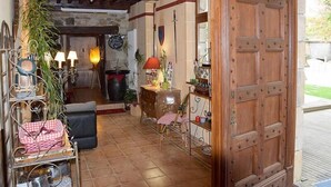 A rustic interior with a wooden door, a stone fireplace, and a dining area with a table and chairs.