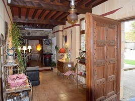 Un interior rústico con una puerta de madera, una chimenea de piedra y un comedor con una mesa y sillas.