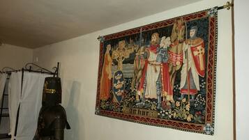 Un tapiz medieval con el nombre 'Arthur', un caballero con armadura y una cruz.