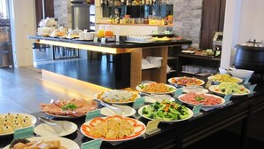 A buffet with various dishes, a coffee station, and a bar area with a large black pot. - Spring Fountain Hotel (Jiaoxi)