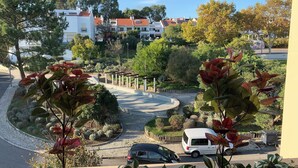 A residential area with a roundabout, parked vehicles, and houses with red-tiled roofs. - Discovery Apartment Carnaxide (Oeiras)