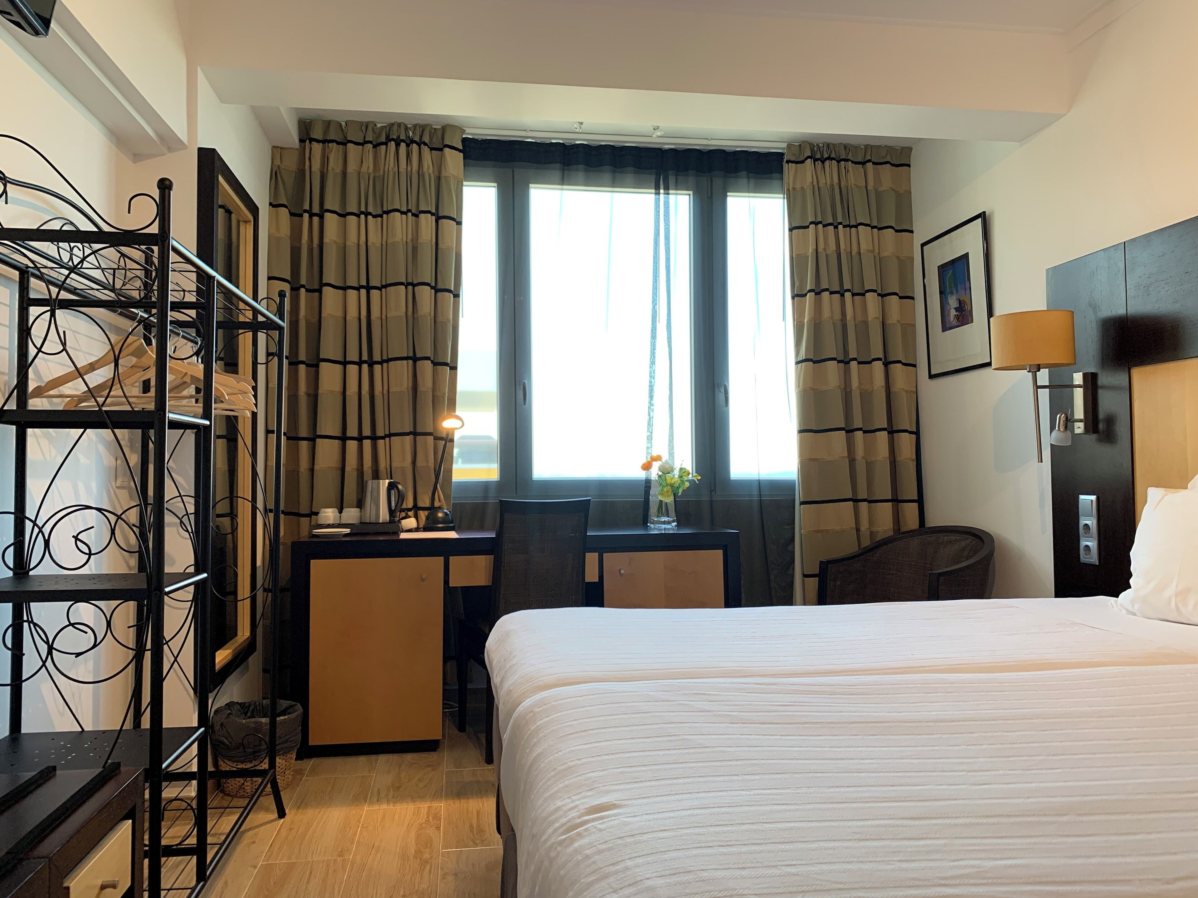 Una habitación de hotel con cama, escritorio, silla y armario.