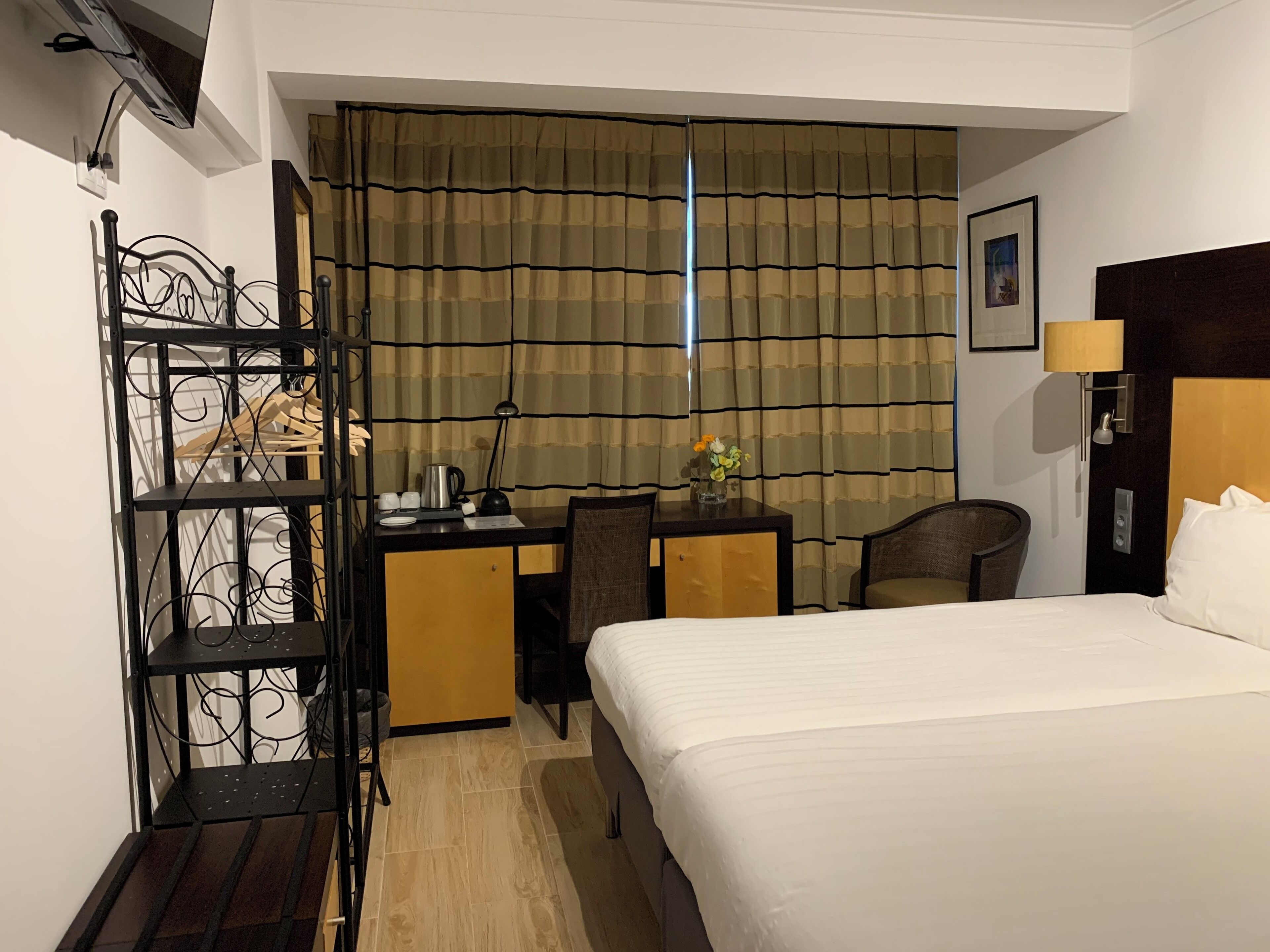 Habitación de hotel con cama, escritorio, silla y armario.