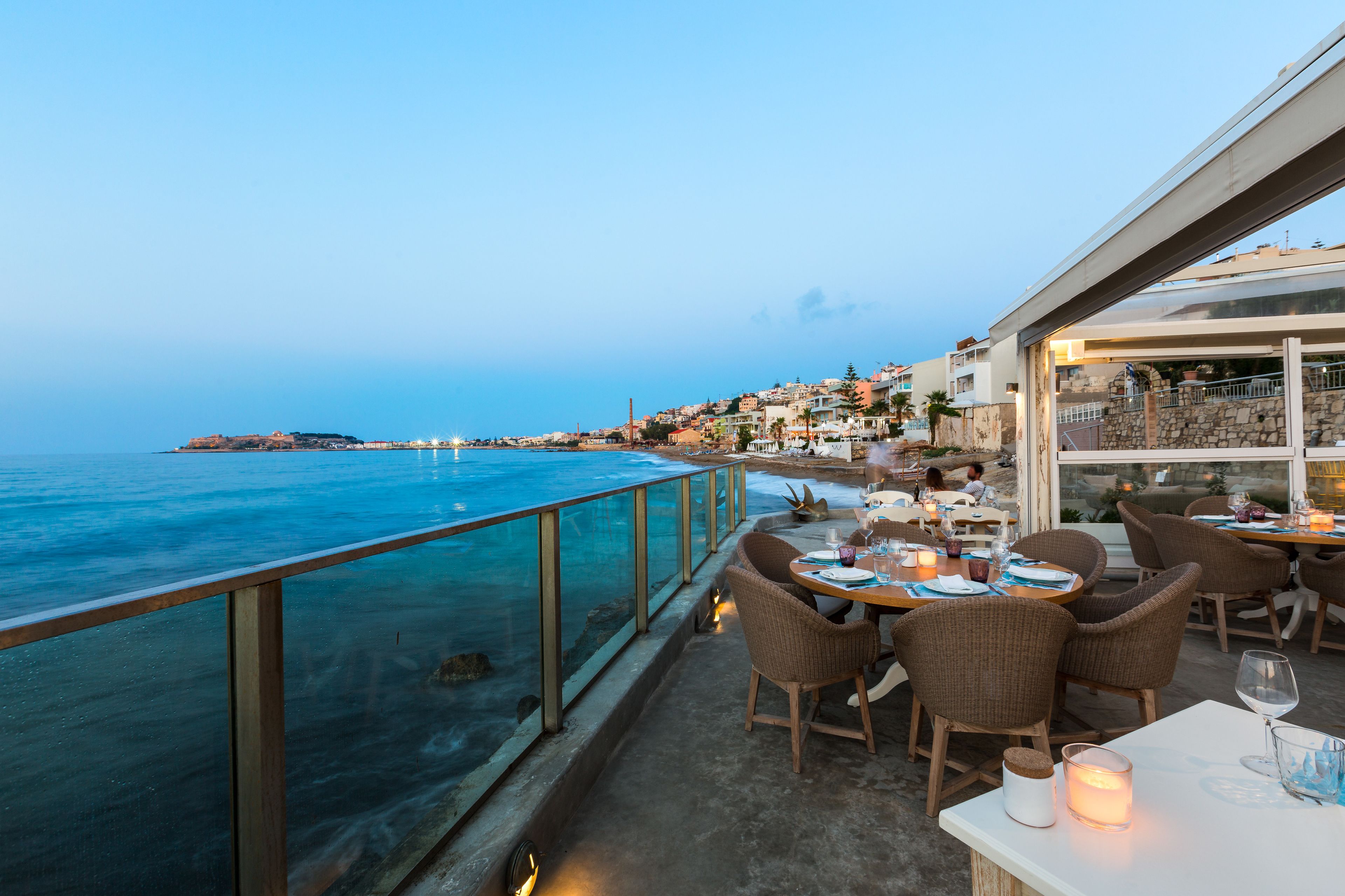 A seaside restaurant with outdoor seating overlooking the ocean.
