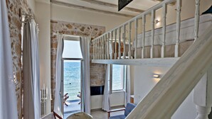 Habitación con vista al mar, una escalera y una zona de estar.