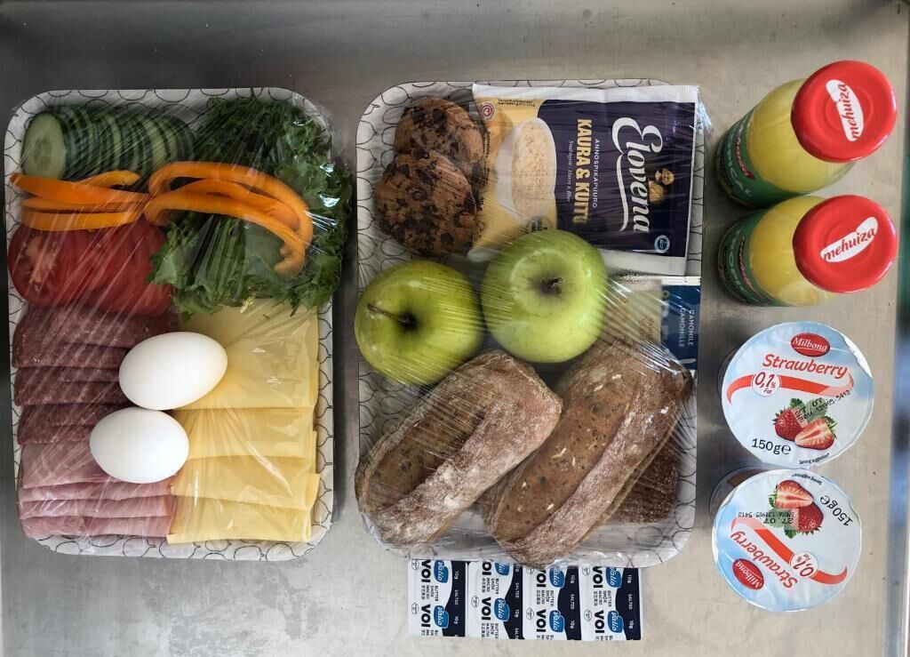 Preparación de comida con verduras, carne, huevos, pan y bebidas envasadas.