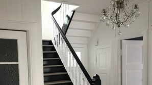 A staircase with black railings and a chandelier. - Lilandtunet Apartments Voss (Voss)