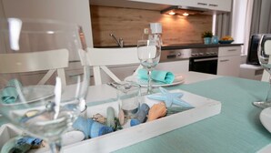 Une table à manger dressée avec des verres à vin, un plateau orné de coquillages et une étoile de mer.