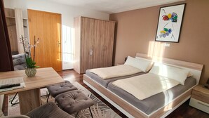 Une chambre à coucher moderne avec un lit, des tables de chevet, un bureau et une chaise.