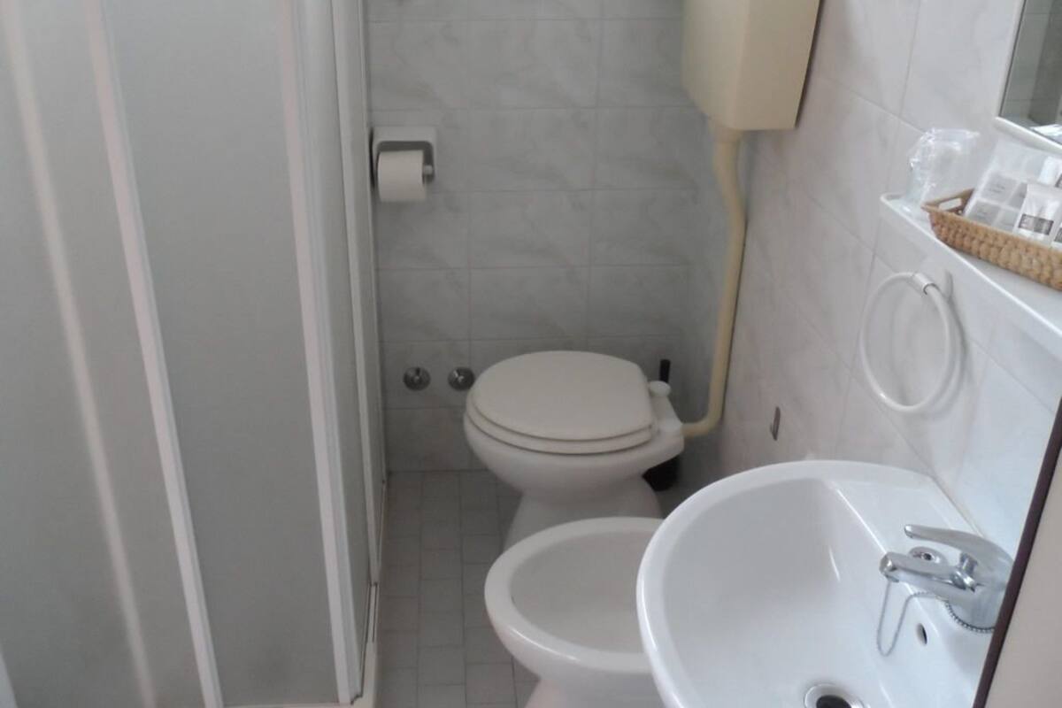 Ein kleines Badezimmer mit Toilette, Bidet und Waschbecken.