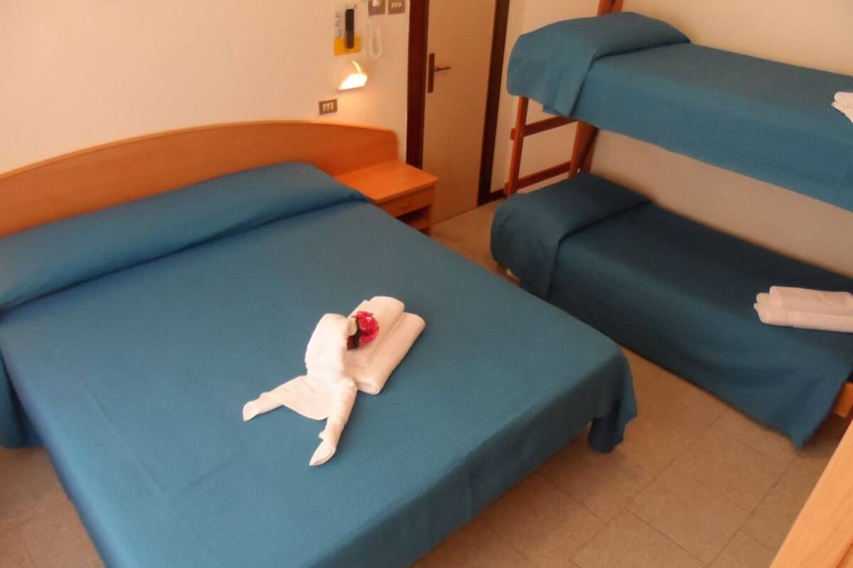Ein Hotelzimmer mit zwei Einzelbetten und einem hölzernen Kopfteil.