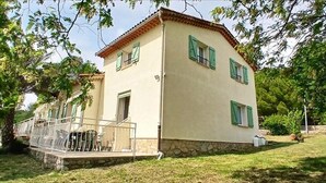 A two-story building with a stone base, green shutters, and a balcony with metal railings. - Quiet cottage in the countryside (Figanières)