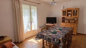 A dining area with a table, chairs, a television, and a cabinet. - Quiet cottage in the countryside (Figanières)