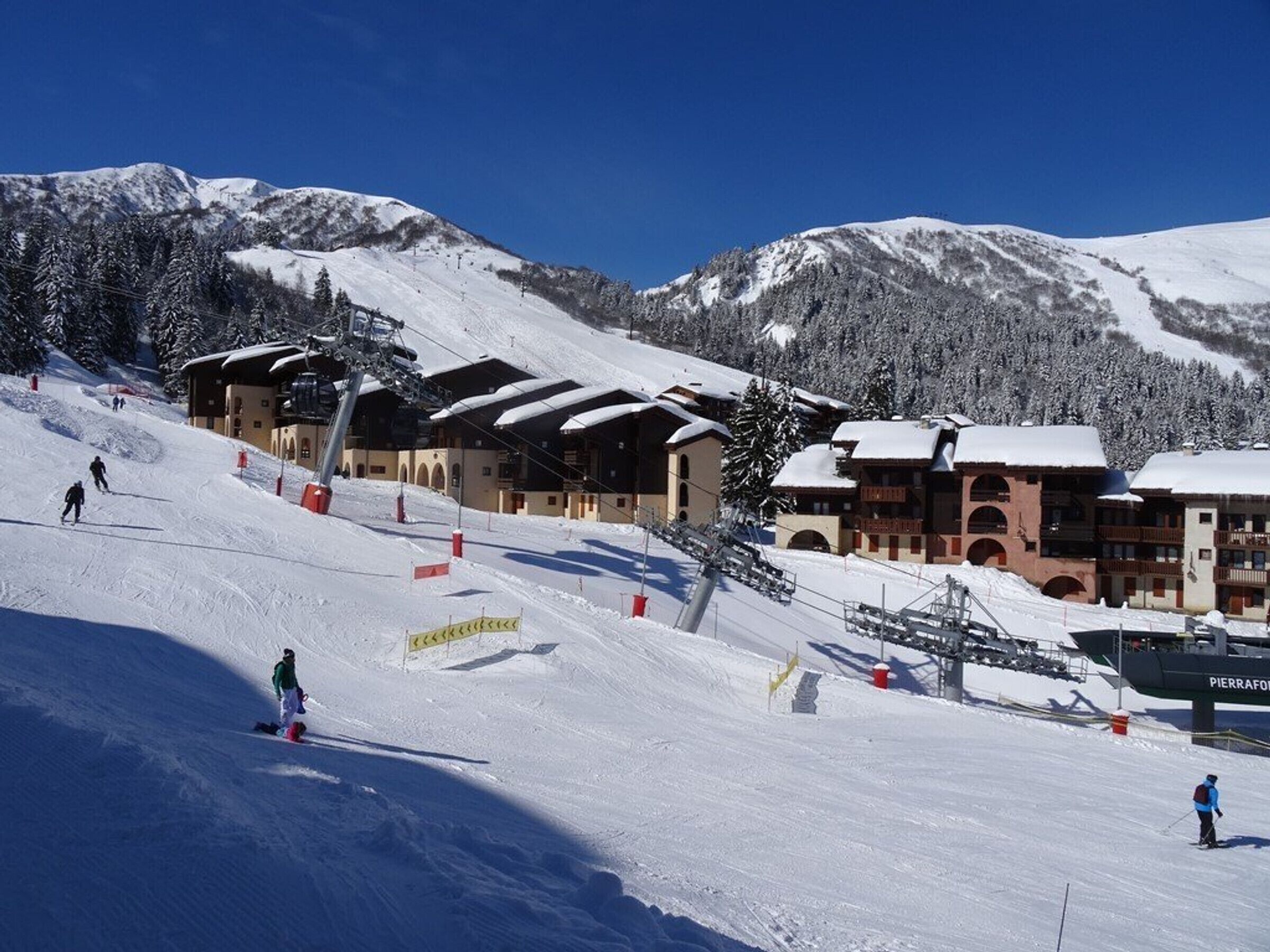 A ski resort with snow-covered slopes, ski lifts, and buildings with traditional architecture.