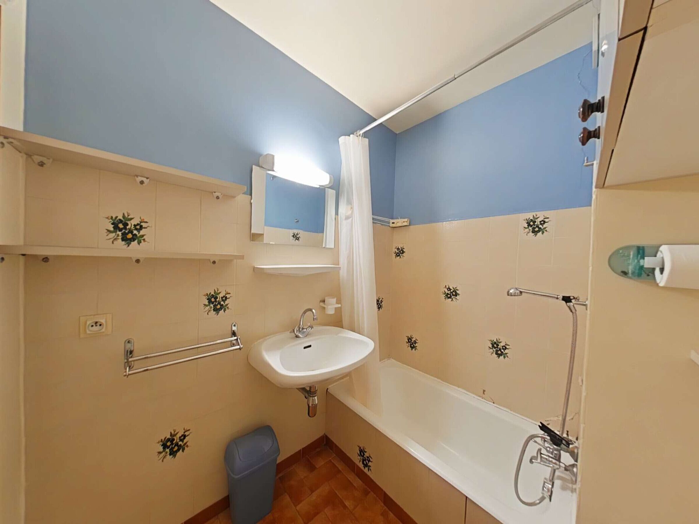 A bathroom with a sink, mirror, shower, and toilet.