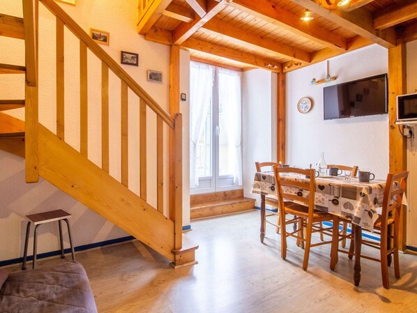 A wooden staircase leading to a dining area with a table set for two.