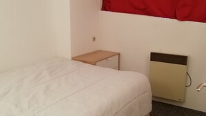 A small, neatly made bed in a room with a single bedside table and a radiator. - 3-room duplex for 6, valley view, near slopes, pets allowed in Arc 1800 (Les Arcs 1800)
