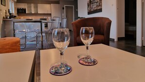 A modern kitchen with white cabinets, a dining area with a table and chairs, and a living room with a brown sofa. - Renovated apartment in Banyuls-sur-Mer with terrace (Banyuls-sur-Mer)