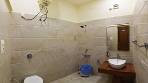 A bathroom with a toilet, sink, and shower. - Hotel Palace (Amritsar)