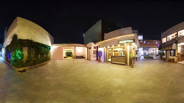 A hotel with a reception area, a reception desk, and a curved building with multiple floors. - Hotel Palace (Amritsar)
