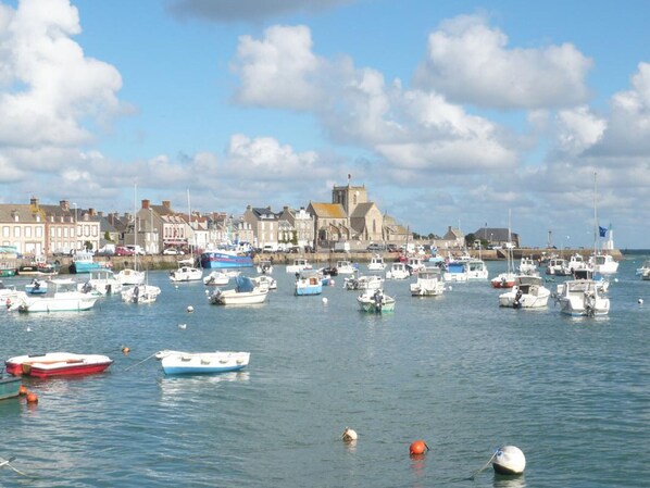 A harbor with numerous boats, a church, and buildings along the waterfront.
