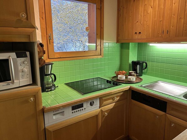 A kitchen with a microwave, coffee maker, and Bosch dishwasher.