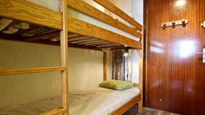 A bunk bed room with a wooden door and a patterned carpet.
