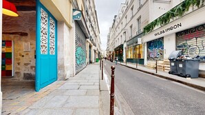 A narrow street with buildings on either side, including a shop with a sign that reads "WILD&MOON".