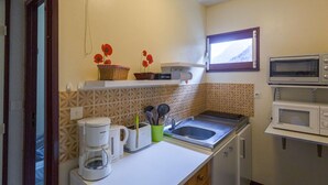 A compact kitchen with a microwave, toaster, and coffee maker on the counter. - Cozy 1BR Apartment for 4 with Balcony, Near Ski Lift and Amenities in Cauterets (Cauterets)