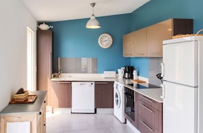 A modern kitchen with a dishwasher, washing machine, and a coffee maker.