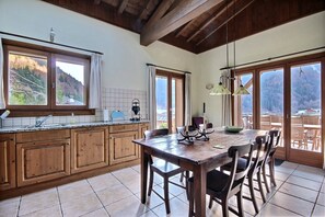 Enjoy meals in this kitchen with a dining table and chairs, offering a view of the surrounding landscape.