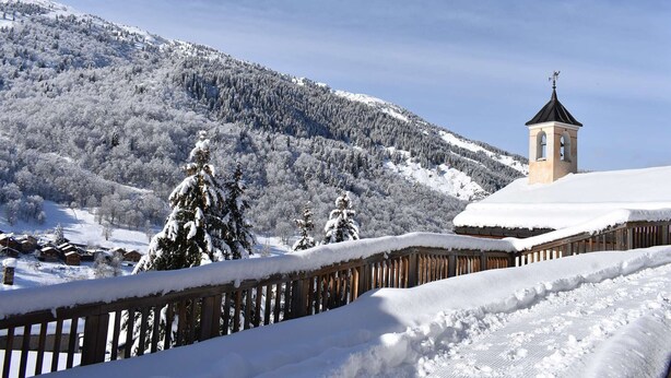 A snow-covered mountain landscape with a wooden fence and a small bell tower. - Traditional chalet for 8 in Méribel, calm and picturesque (Méribel)