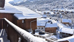 A snow-covered village with wooden buildings and a mountain backdrop. - Traditional chalet for 8 in Méribel, calm and picturesque (Méribel)