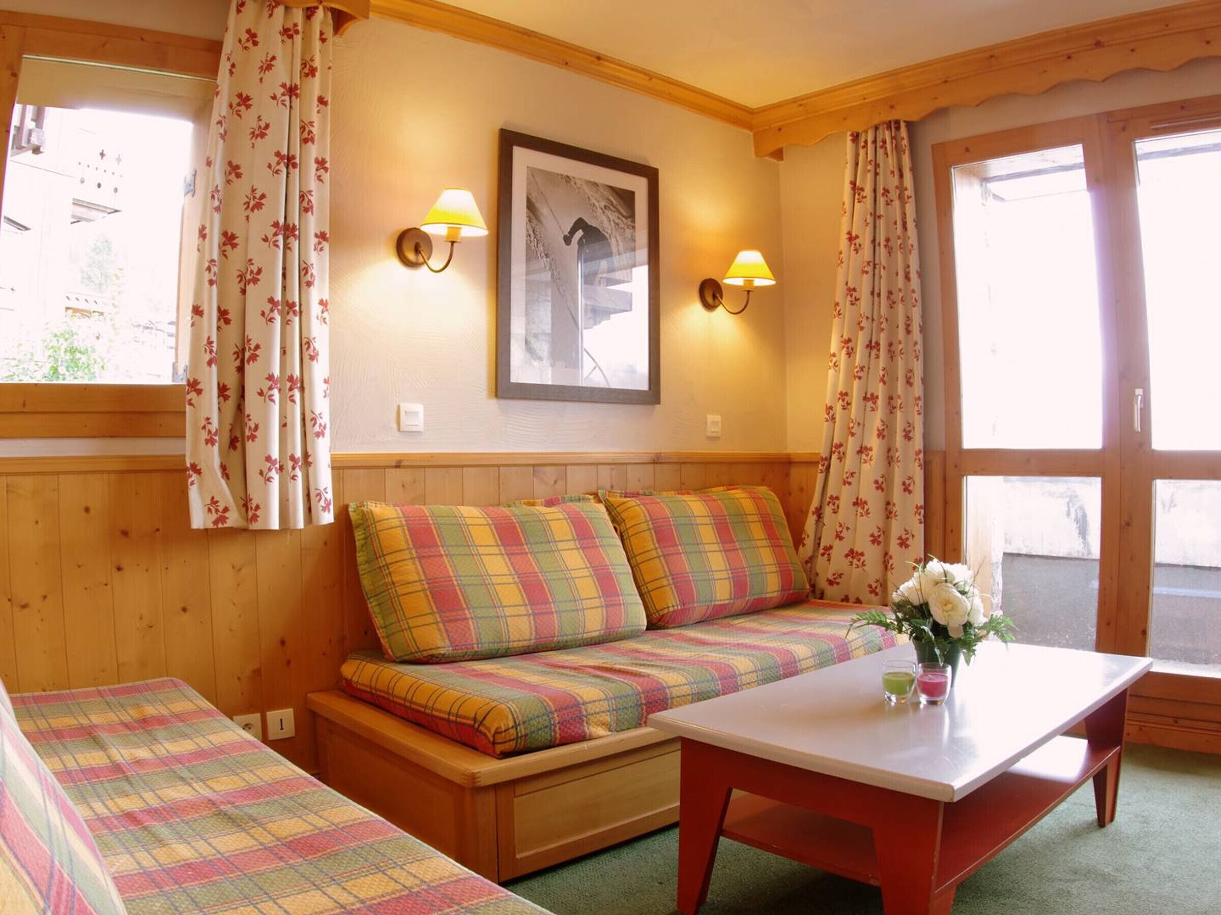 A cozy room with a wooden bench, a small table, and a wall-mounted picture.