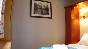 Une chambre d’hôtel avec un lit, un tableau encadré au mur et une table de chevet.
