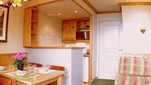 Un espace de vie compact comprenant un coin repas, une kitchenette et un canapé.