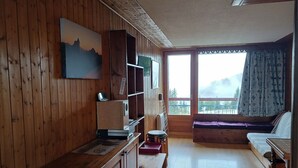 A wooden-paneled room with a large window, a painting, and a wooden bench. - Studio 5 pers, ski-in/ski-out, near shops (Les Arcs 1800)