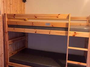 A bunk bed with a wooden frame and a mattress.