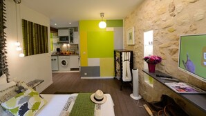 A compact living space with a kitchen, a dining area, and a bedroom. - C2D Green Valley (París)