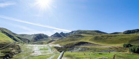 A train on a track with a mountainous landscape in the background.