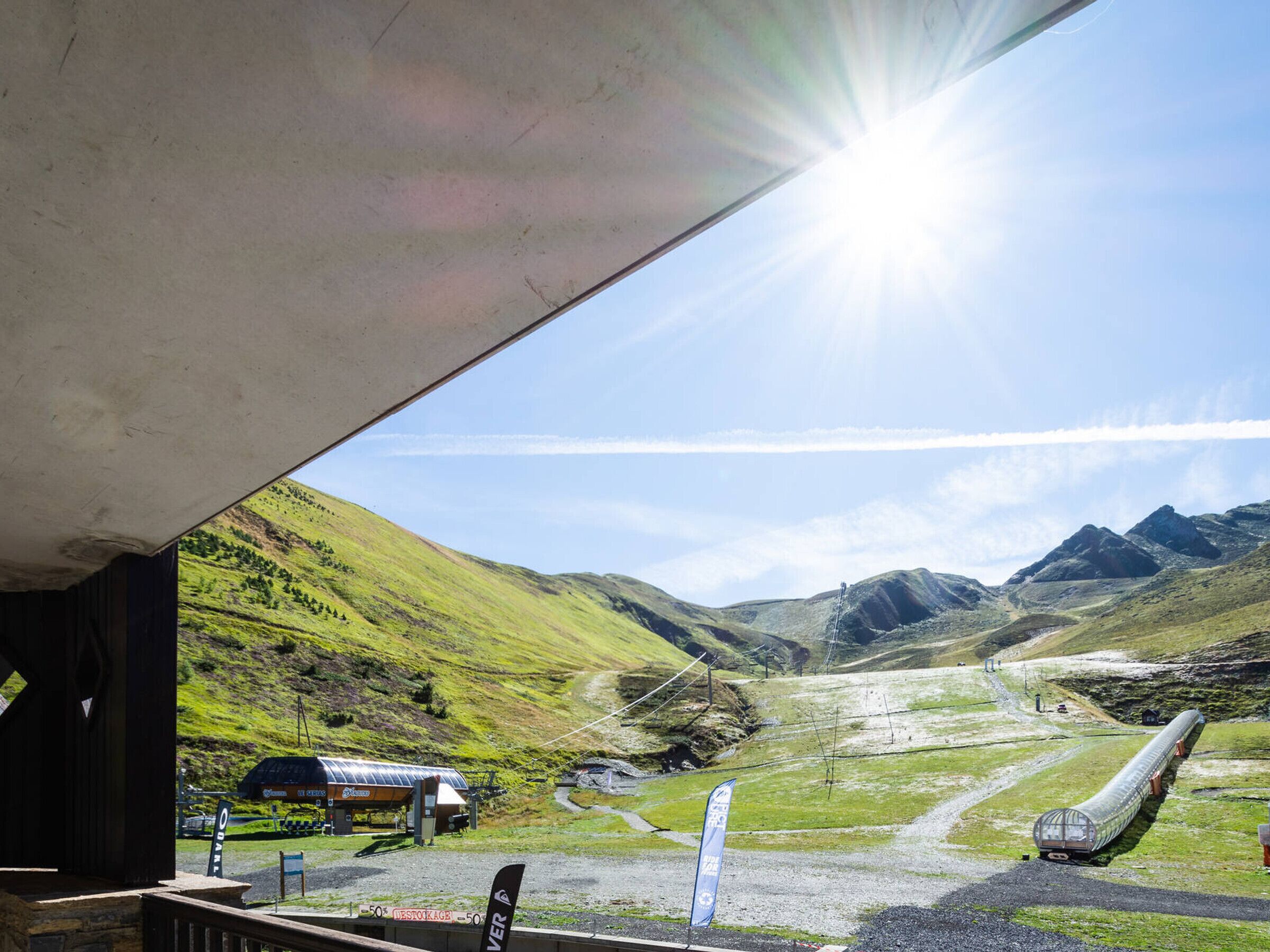 A ski resort with a chairlift, a ski lodge, and a mountain backdrop.