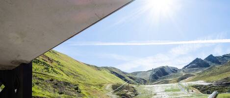 A ski resort with a chairlift, a ski lodge, and a mountain backdrop.