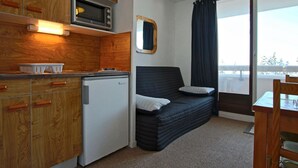 A compact kitchenette with a microwave, a small refrigerator, and wooden cabinets. - Functional studio for 4, pets allowed (Chamrousse)