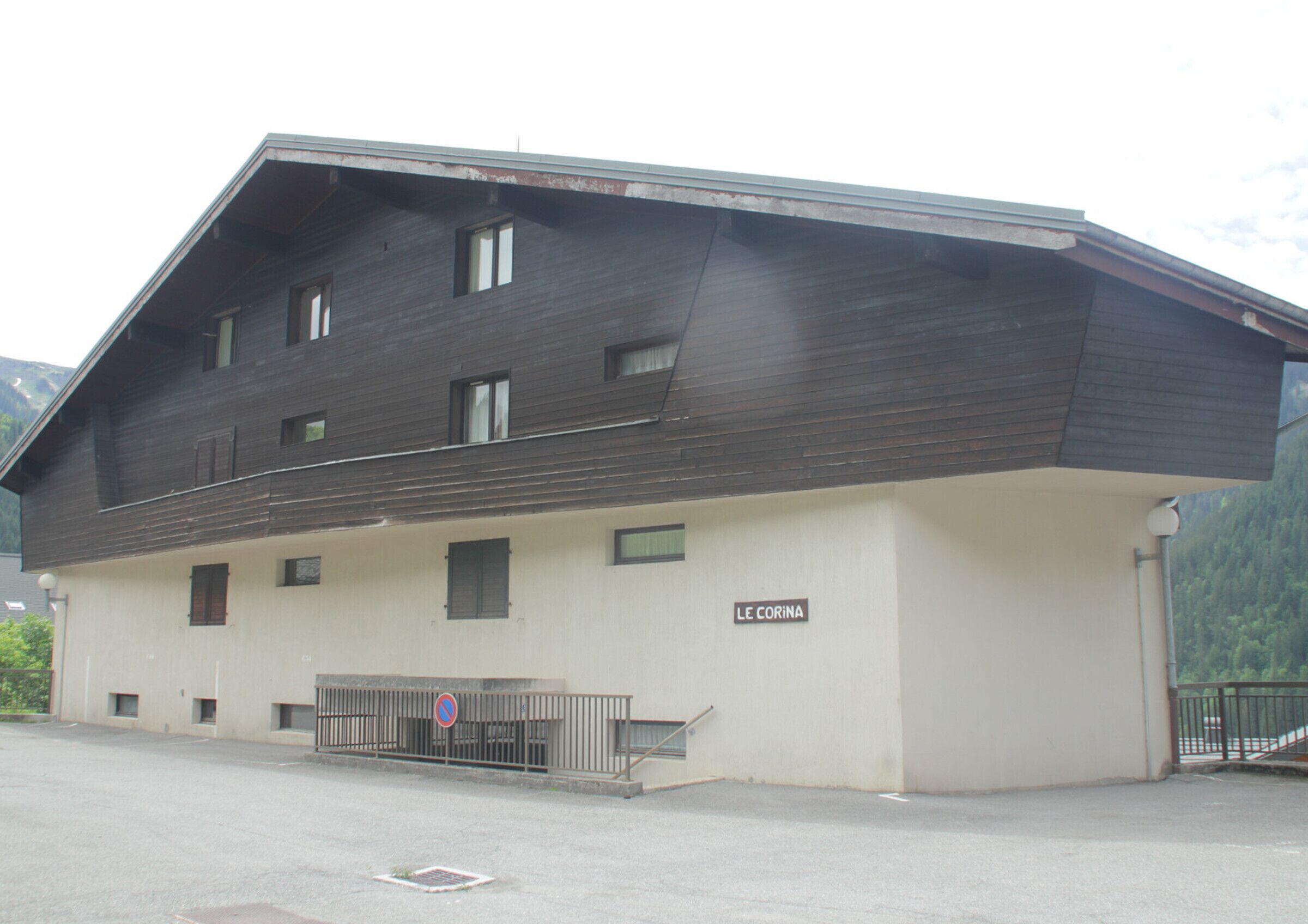 Ein zweistöckiges Gebäude mit dunkler Holzfassade und einem hellen Unterteil.