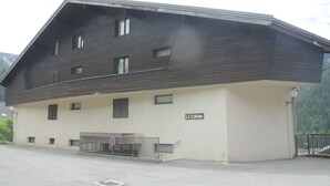 Un bâtiment à deux étages, doté d’une façade en bois foncé et d’une partie inférieure de couleur claire.