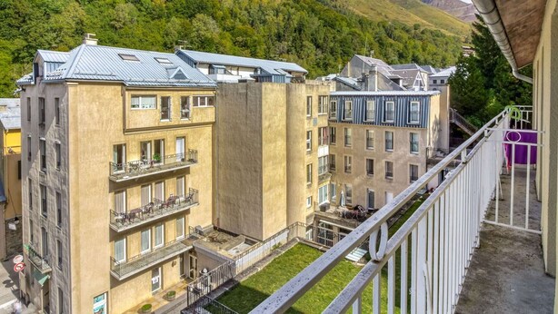 Un hotel a più piani con balconi e vista su un paesaggio montuoso.