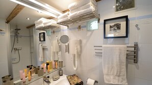 A modern bathroom with a glass shower enclosure, a vanity with toiletries, and a towel rack. - E5GG Honey Mustard (París)