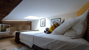 A bedroom with a bed, a television, and framed pictures on the wall. - E5GG Honey Mustard (París)