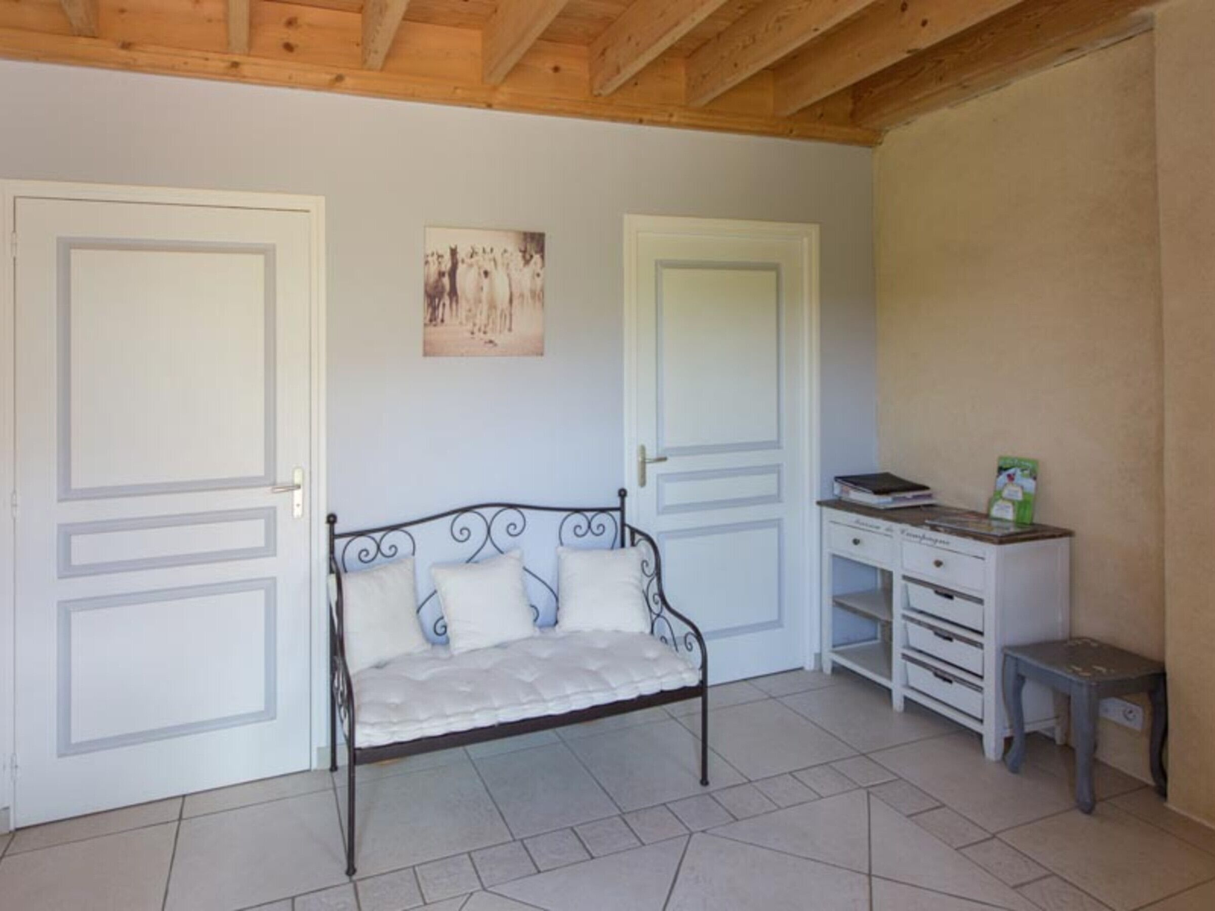 A bedroom with a bed, a desk, and two doors.