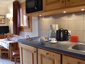 A compact kitchen with a microwave, coffee maker, and kettle on the counter. - Charming Renovated Studio for 3 Near Slopes with Balcony in Méribel (Méribel)